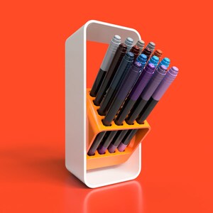 May include: A white stand with an orange holder for coloured markers. The markers are arranged in a fan shape and are mostly shades of blue, purple, and brown.