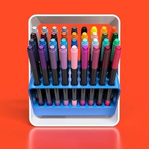 May include: A white plastic holder with a blue base containing a variety of coloured markers. The markers are arranged in rows and are all the same size.