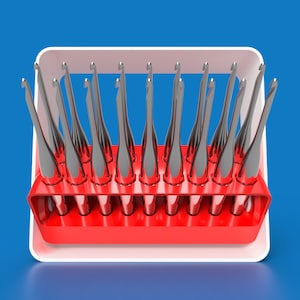 May include: A red and white plastic organizer with 14 slots for holding crochet hooks. The hooks are silver and are arranged in the slots.