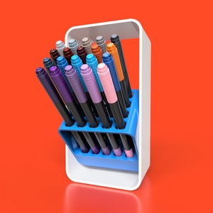 May include: A white and blue pen holder with a variety of coloured pens. The pens are arranged in a vertical row and are all different colours, including blue, green, purple, orange, and pink.