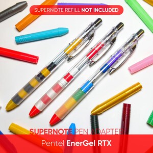 May include: An assortment of colorful pens and refills are scattered on a white surface. The pens have clear barrels with various colored ink sections. The image includes the text "SUPERNOTE REFILL NOT INCLUDED" and "SUPERNOTE PEN ADAPTER Pentel EnerGel RTX".