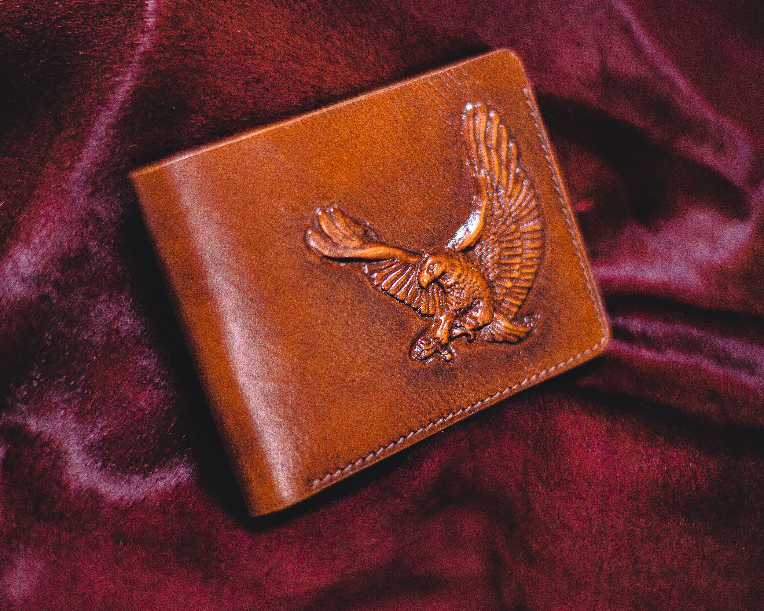 Leather coin-pocket wallet with all-over embossed eagle