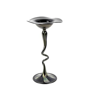 Könnte beinhalten: Eine dekorative schwarze Glasvase mit einem breiten, geriffelten Oberteil und einem schlanken, spiralförmigen Stiel. Die Vase hat einen kreisförmigen Sockel und ist mit goldenen und cremefarbenen Streifen akzentuiert. Das elegante Design eignet sich zum Präsentieren von Blumen oder als dekoratives Element.