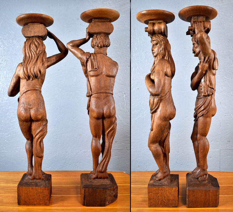 Puede incluir: Dos esculturas de madera de figuras que llevan una bandeja en la cabeza. Las figuras est&aacute;n talladas en un estilo realista y est&aacute;n acabadas en un tono de madera natural.