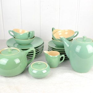 Può includere: Un set da tè vintage di colore verde chiaro con una teiera, un creamer, uno zuccheriera, tazze e piattini.