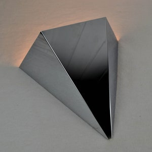 May include: A shiny, silver, triangular-shaped wall sconce with a modern design.