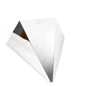 May include: A silver, geometric, triangular sculpture with a reflective surface.