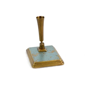 Op de afbeelding: Een gouden pennenhouder met een blauwe en gouden basis. De houder heeft een cilindrische vorm en een glad oppervlak.