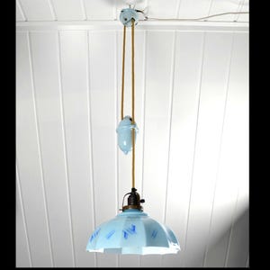May include: A blue and white porcelain ceiling light fixture with a pull chain. The light fixture is hanging from a white ceiling.