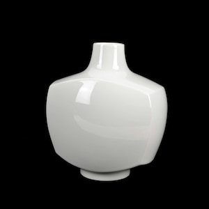 Könnte beinhalten: Eine weiße Keramikvase mit einem abgerundeten, leicht ausgestellten Boden und einer breiten, abgerundeten Öffnung. Die Vase hat eine glatte, glänzende Oberfläche.
