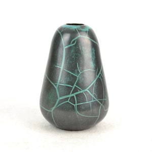 May include: A dark green ceramic vase with a crackled glaze and a pear-shaped silhouette.