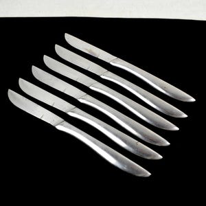 Può includere: Set di sei coltelli da burro in acciaio inossidabile argentato con manici leggermente curvi.