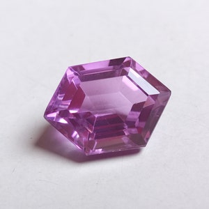 May include: A faceted, octagonal, purple gemstone with a clear, glassy finish.
