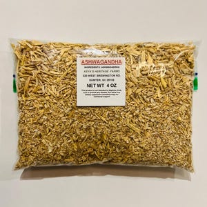 May include: A clear plastic bag filled with light brown, chopped pieces of ashwagandha. The bag has a white label with the text "ASHWAGANDHA" and "NET WT 4 OZ". The bag is sealed with green and blue tape.