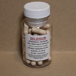 May include: A clear plastic bottle filled with beige capsules labeled "SELENIUM 100% VEGETABLE CAPSULES INGREDIENTS: SELENIUM ASYA'S ORGANIC FARMS 320 WEST BREWINGTON RD. SUMTER, SC 29153 50 VEG. CAPSULES This product is not intended to diagnose, treat, cure or prevent any disease, but rather is a dietary supplement intended solely for nutritional support"