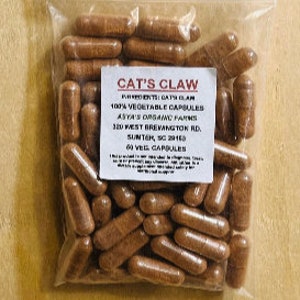 May include: A bag of 60 brown capsules labeled "CAT'S CLAW 100% VEGETABLE CAPSULES ASYA'S ORGANIC FARMS 320 WEST BREVANGTON RD SUNTER, SC 2916"