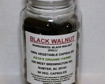 May include: A clear plastic bottle filled with dark brown capsules. The label reads "BLACK WALNUT" and lists ingredients and other details. The bottle has a white screw-on cap. The capsules are 100% vegetable capsules.