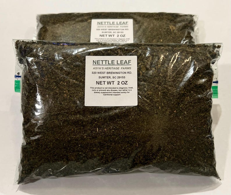 May include: Two clear plastic bags filled with dried nettle leaf. Each bag has a white label with the text "NETTLE LEAF" and "NET WT 2 OZ". The labels also include the seller's farm name and address.