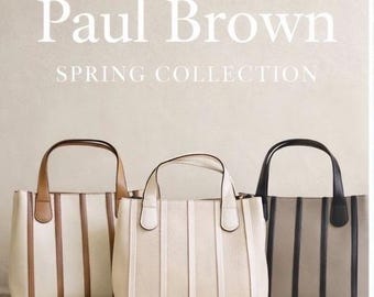 Puede incluir: Tres bolsos tote estructurados con paneles verticales y dos asas. El bolso de la izquierda es crema con paneles color canela, el central es crema y el de la derecha es gris con paneles negros. El texto dice: Paul Brown SPRING COLLECTION.