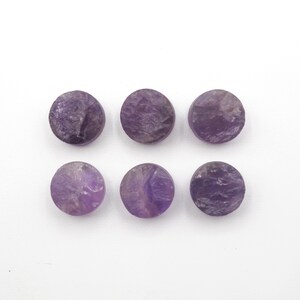 May include: Six round, purple amethyst cabochons with a rough, textured surface.