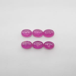 May include: Six oval-shaped pink gemstones, arranged in two rows of three.