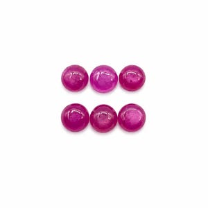 May include: Six round, cabochon-cut gemstones in a vibrant magenta-pink color. Each stone features a smooth, polished, domed surface with a glossy finish, arranged in two horizontal rows of three, displaying consistent size and circular shape.