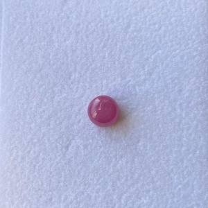May include: A round, pink gemstone with a smooth, polished surface.