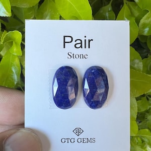 May include: Pair of blue lapis lazuli oval shaped stones on a white card with the text "Pair Stone" and "GTG GEMS".