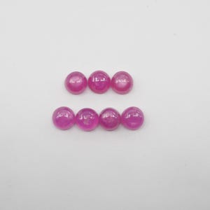 May include: Six round pink cabochon gemstones arranged in two rows of three.
