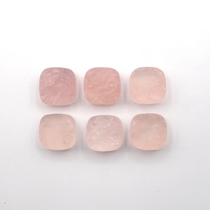 May include: Six square-shaped, pale pink rose quartz cabochons. The cabochons are smooth and have a slightly cloudy appearance.