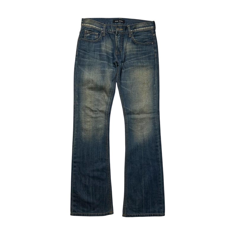 May include: Blue denim jeans with a faded wash and a slight bootcut. The jeans have a classic five-pocket design, a button and zipper closure, and belt loops. The denim has a worn appearance.