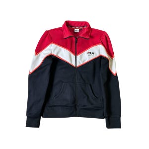 K&ouml;nnte beinhalten: FILA-Trainingsjacke mit Rei&szlig;verschluss in Rot, Wei&szlig; und Marineblau. Die Jacke hat ein Zickzackmuster auf Brust und Schultern, mit dem FILA-Logo auf Brust und Kragen. Sie hat einen durchgehenden Rei&szlig;verschluss und zwei Vordertaschen.