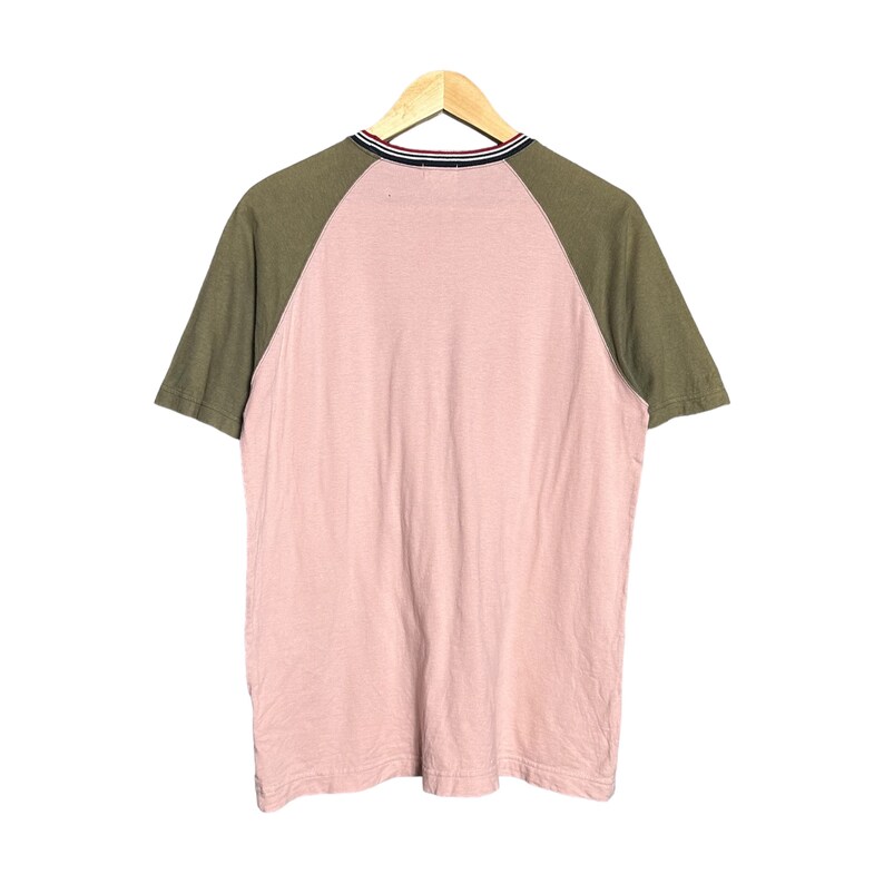 May include: A pink and green short-sleeved t-shirt with a contrasting color design. The shirt has a crew neck and a striped trim around the neck.