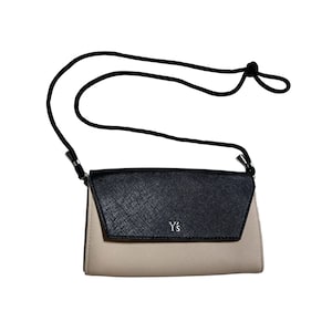 May include: A black and beige leather crossbody bag with a silver Y's logo.