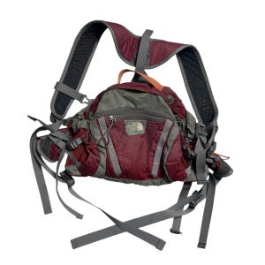 Op de afbeelding: Een rode en grijze The North Face wandelrugzak met verstelbare banden en meerdere zakken.