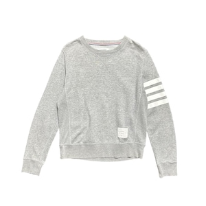 May include: A grey sweatshirt with a crew neck and long sleeves. The left sleeve has three white stripes. A small label is sewn on the lower front. The neckline has a red, white, and blue stripe detail.