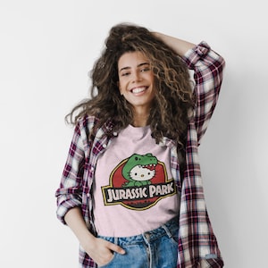 Hello Kitty Jurassic Park T-Shirt | Kawaii Dinosaur Mashup Tee | Cute Pink Graphic Shirt | Unisex Cotton Tee | Funny Movie Crossover Gift