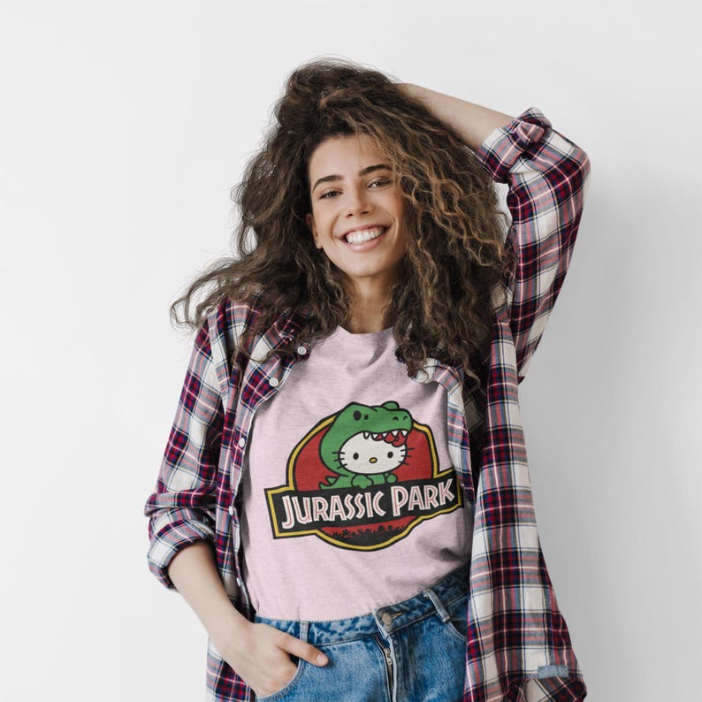 Hello Kitty Jurassic Park T-Shirt | Kawaii Dinosaur Mashup Tee | Cute Pink Graphic Shirt | Unisex Cotton Tee | Funny Movie Crossover Gift image 1