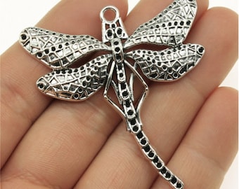 Könnte beinhalten: Silberfarbener Libellen-Anhänger mit filigranen Details und einem zarten Design. Der Anhänger hat oben eine Öse zum Anbringen an Schmuck oder andere Bastelarbeiten.