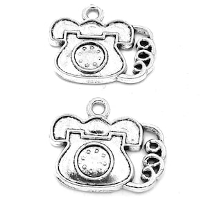 May include: Two silver-toned rotary phone charms with a curled cord detail.