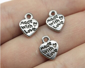 May include: Three silver heart-shaped charms with the words "Made with Love" and a small heart symbol.