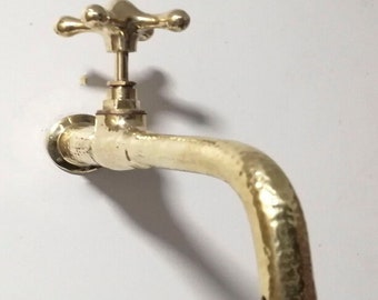 Puede incluir: Un grifo de latón dorado con una manija en forma de cruz. El grifo tiene un acabado texturizado y un caño curvo.