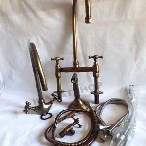 Puede incluir: Grifo de cocina de latón antiguo con dos manijas cruzadas y un rociador separado. El grifo viene con dos mangueras trenzadas y dos mangueras flexibles.