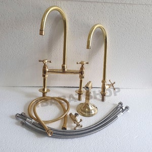 May include: A gold-tone brass double-handle kitchen faucet with a high-arc spout and a separate sprayer. The faucet comes with a set of flexible hoses for installation.