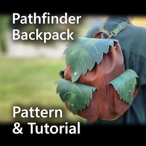 Może przedstawiać: Brązowy skórzany plecak z zielonymi akcentami w kształcie liści na klapie i kieszeniach. Plecak ma zapięcie na sznurek i regulowane paski. Tekst "Pathfinder Backpack Pattern & Tutorial" jest wyświetlany na biało.