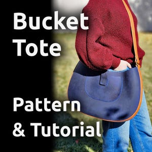 May include: A blue leather bucket tote bag with a brown strap. The bag is worn by a person wearing a red sweater and blue jeans. The text "Bucket Tote Pattern & Tutorial" is visible in the image.