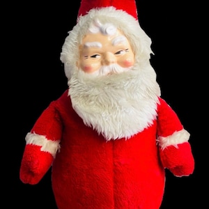 May include: A vintage plush Santa Claus doll with a white beard and a red suit. The doll has a white fur trim around the hat and sleeves.