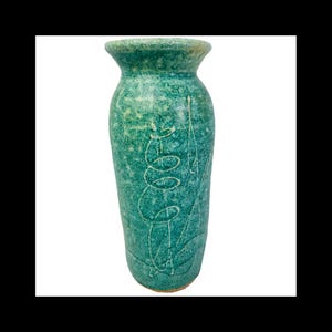 May include: A green ceramic vase with a white glaze and a swirling design.