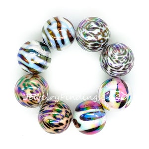 May include: A strand of iridescent white and brown round beads with a leopard print pattern. The beads are strung together to form a bracelet.