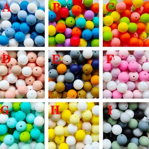 May include: Assortment of 9 different colors of silicone beads. The beads are round and have a hole in the center. The colors are blue, red, orange, yellow, green, pink, beige, gray, and black.